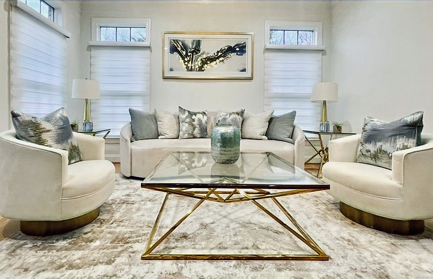 Luxury modern living room interior design featuring velvet swivel chairs, gold geometric glass coffee table, and neutral color palette.